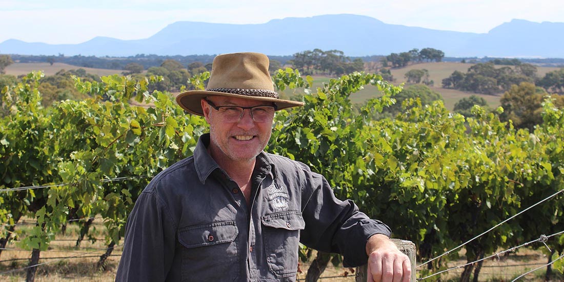 Man posing in the vineyard.